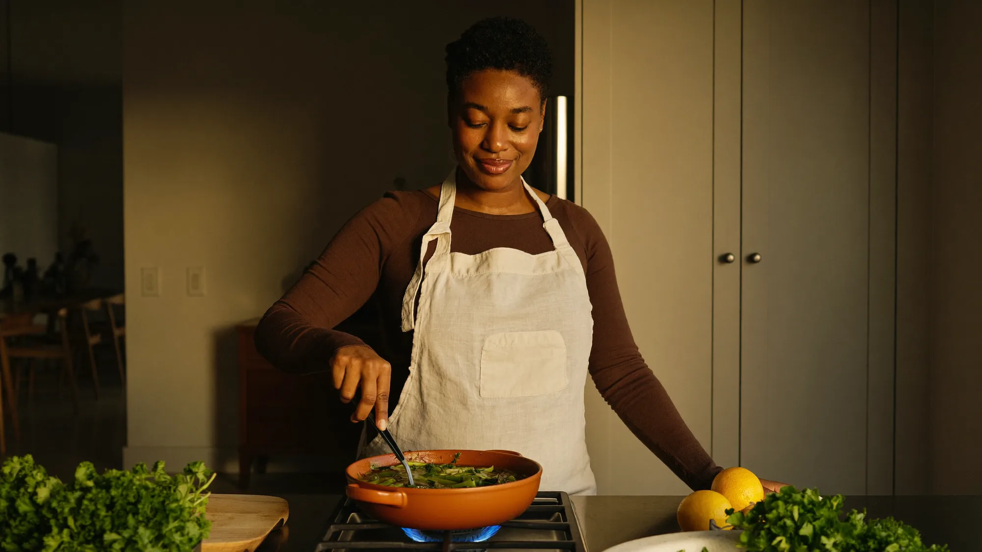 Pregnant woman cooking a vegetable stew in a warm kitchen